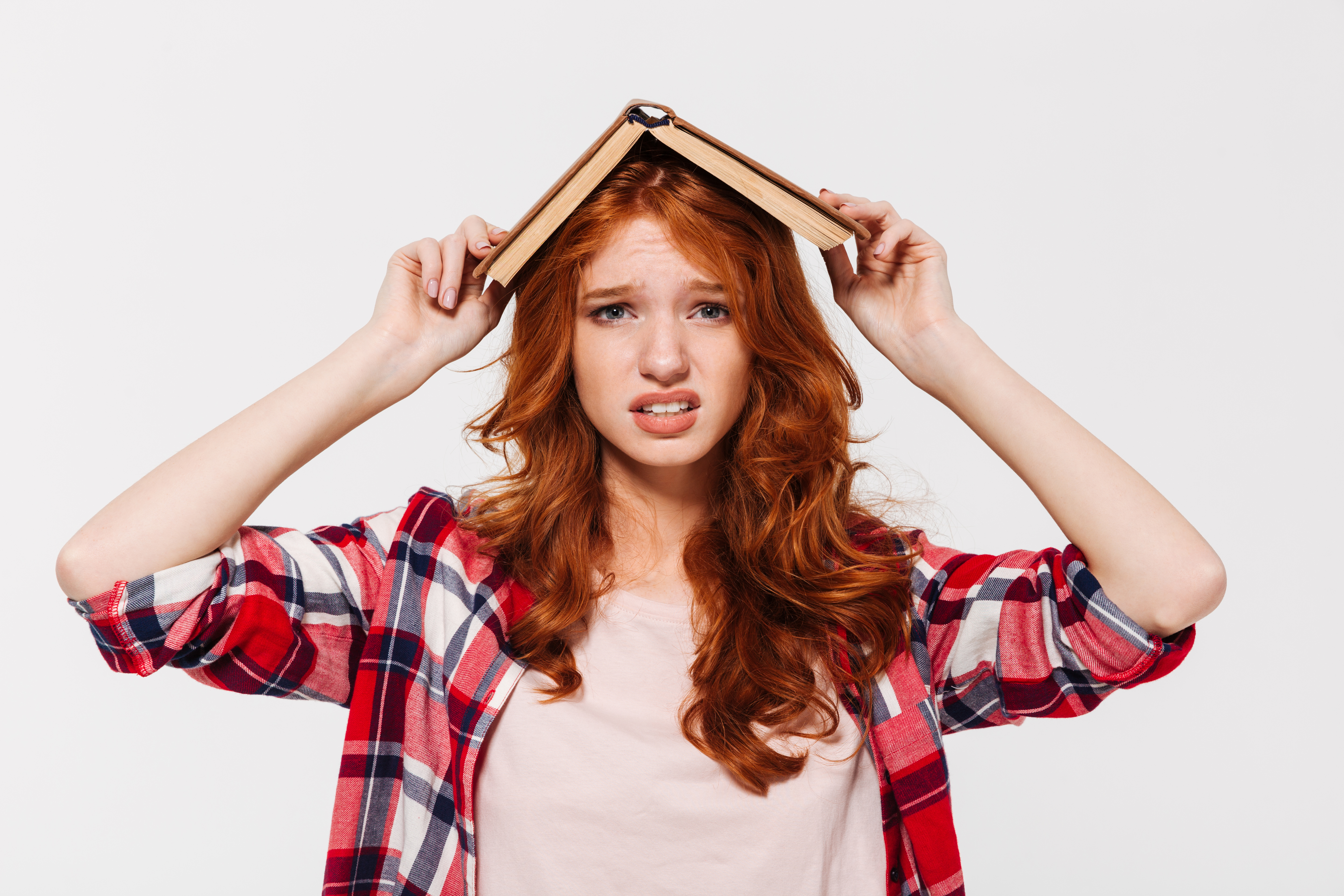 confused-ginger-woman-shirt-holding-book-her-head.jpg
